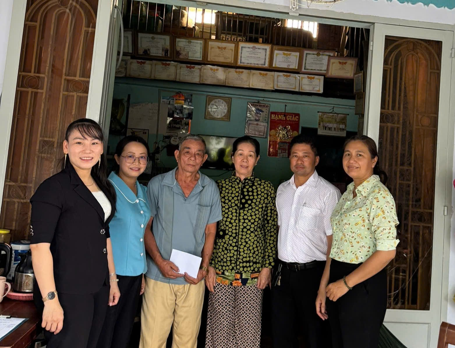 ''A group of people standing in front of a door

Description automatically generated''