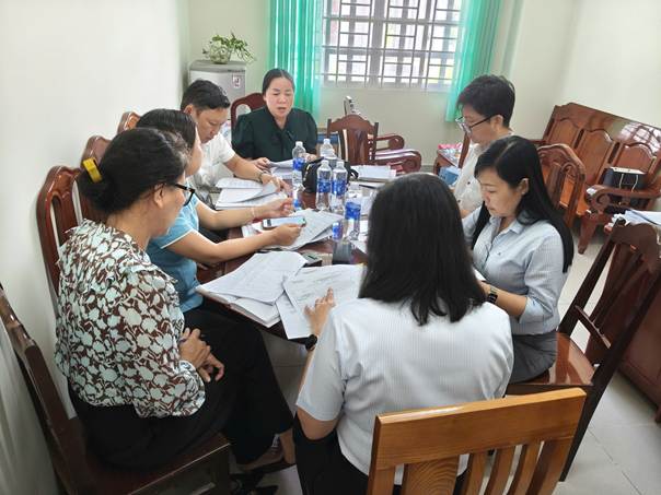 '''A group of people sitting around a table

Description automatically generated'''