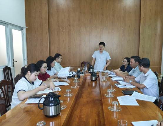 ''A group of people sitting around a long table

Description automatically generated''