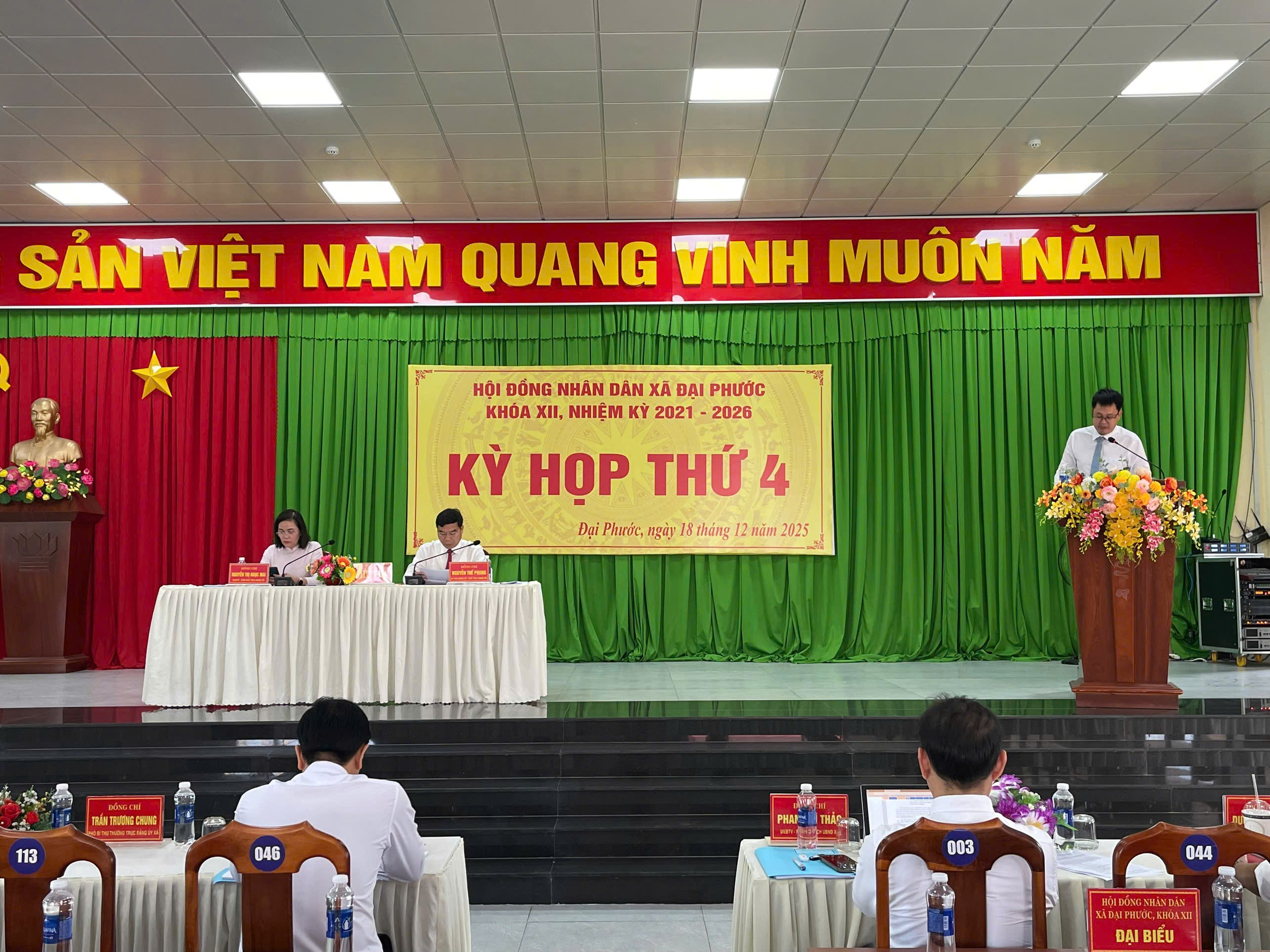 'A group of people sitting at a stage

Description automatically generated'